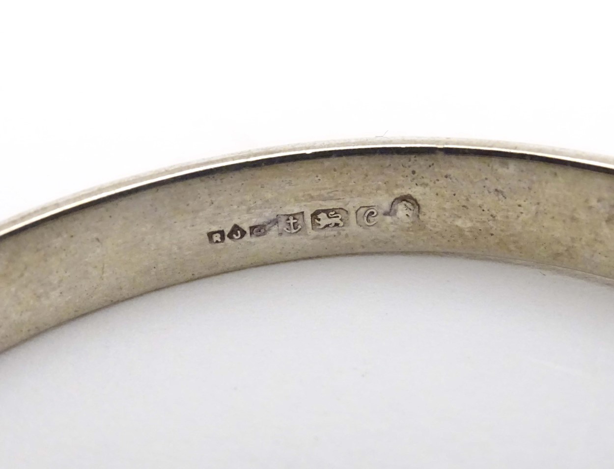 A silver bangle with engraved decoration. Hallmarked Birmingham 1977. Maker R. J. Crafts. - Image 4 of 6