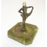 An Art Deco onyx based ashtray with elephantine like figure of gilded bronze and ivorine to middle