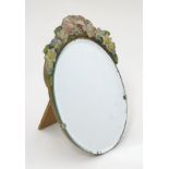 A mid 20thC barbola mirror with flower models adorning the oval top, and with stand to the back.