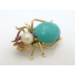 A 14kt gold brooch formed as a spider set with turquoise cabochon body, pearl head and ruby eyes.