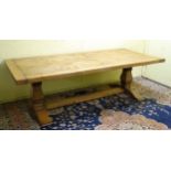 A 20thC oak farmhouse kitchen table / refectory table with over hanging top and trestle base.