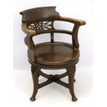 A 19thC oak office chair / captain's chair with pierced back splat and shaped cresting rail,