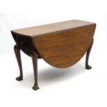 An 18thC Irish drop leaf table of mahogany construction opening to form an oval,
