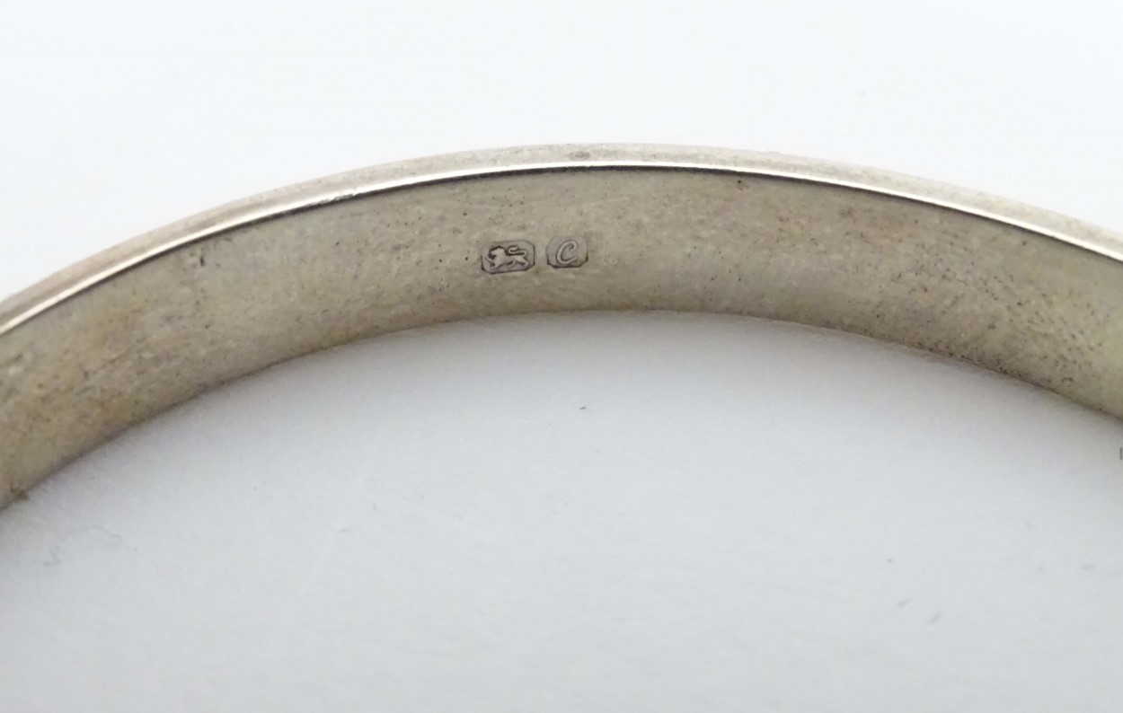 A silver bangle with engraved decoration. Hallmarked Birmingham 1977. Maker R. J. Crafts. - Image 6 of 6