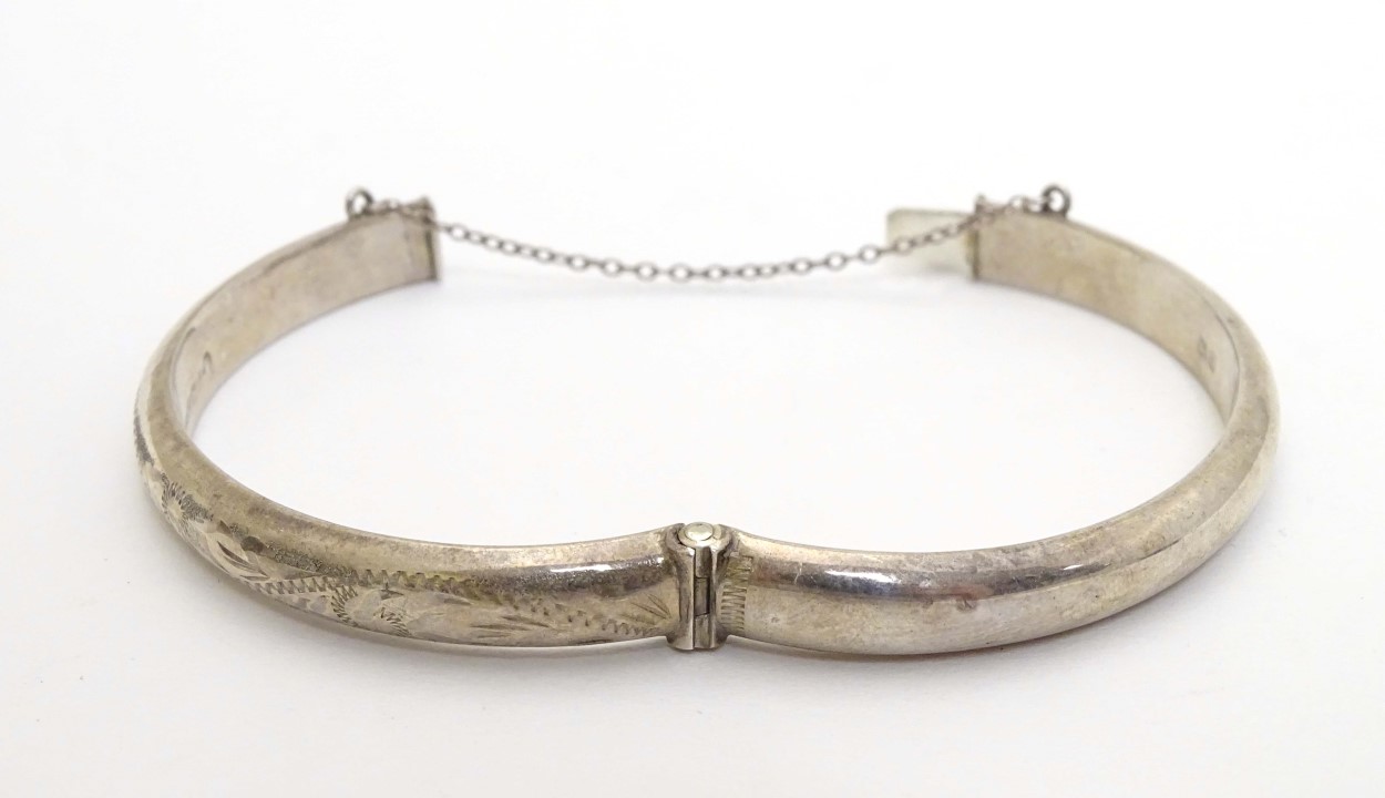 A silver bangle with engraved decoration. Hallmarked Birmingham 1977. Maker R. J. Crafts. - Image 2 of 6