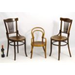 A pair of beech bentwood chairs with spindle back splats and anthemion decorated seats.