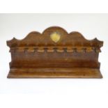 Pipe smoking: An early 20thC oak pipe rack, with provision for nine pipes,