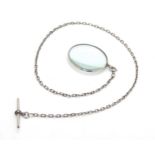 A magnifying glass mounted on a silver and white metal Albert chain.