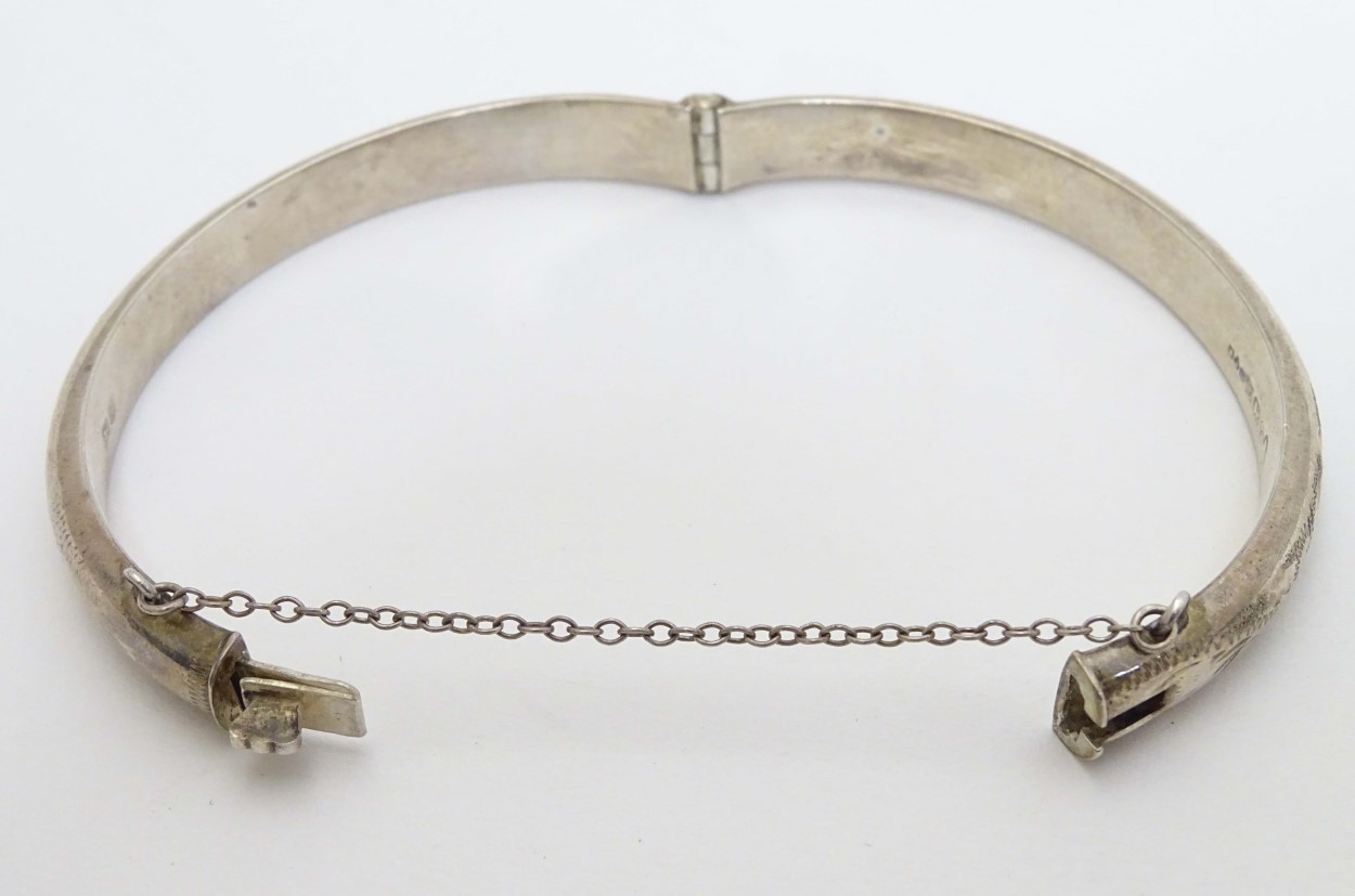 A silver bangle with engraved decoration. Hallmarked Birmingham 1977. Maker R. J. Crafts. - Image 5 of 6