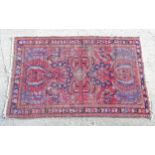 Rug / carpet : a Persian hand made a wine red ground rug with three distinct borders , having blue ,