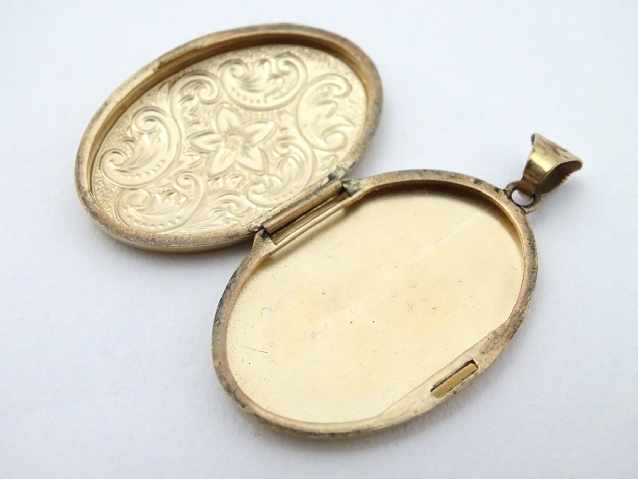 A yellow metal locket of oval form with floral and C-scroll decoration approx 1 1/4" long - Image 4 of 5