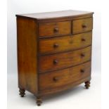 A mid 19thC mahogany bow fronted chest of drawers comprising two short over three long drawers and