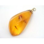 A large amber pendant with gold mount.