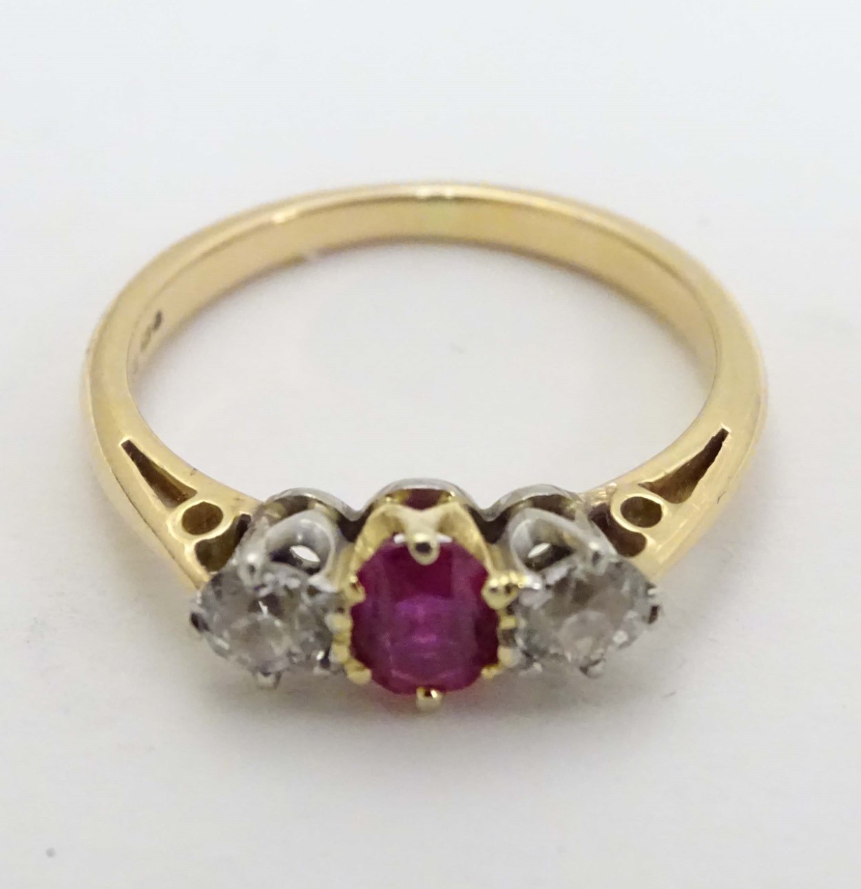 An 18ct gold ring set with central ruby flanked by 2 diamonds.