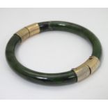 A jade bracelet of bangle form with gilt metal mounts CONDITION: Please Note - we