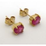 A pair of 9ct gold stud earrings set with red stones.
