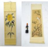 Two oriental hand painted scrolls one depicting a sunflower, one depicting a white,