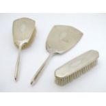A 3 piece silver backed dressing table set comprising brushes and hand mirror hallmarked Birmingham