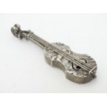 A white metal miniature model of a violin decorated with cherubs in a landscape 3" long