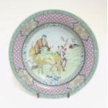 A Chinese Famille Rose plate with a figure on a yellow coloured deer together with a child to
