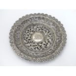 A white metal dish of circular form with acanthus scroll and floral decoration. Possibly Indian.