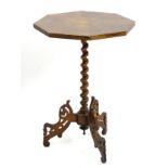 A walnut tripod table with octagonal top above barley twist pedestal and fret work carved legs with