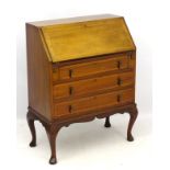 An Edwardian inlaid bureau with fall front opening to reveal pigeon holes and single short drawer