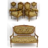 A Louis XVI style walnut salon suite to include a settee, two armchairs, and four side chairs.