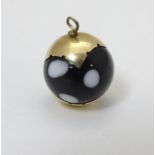 A glass pendant of spherical form with yellow metal mounts.