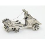 A Continental silver miniature model of a figure in a chariot being pulled by horses.