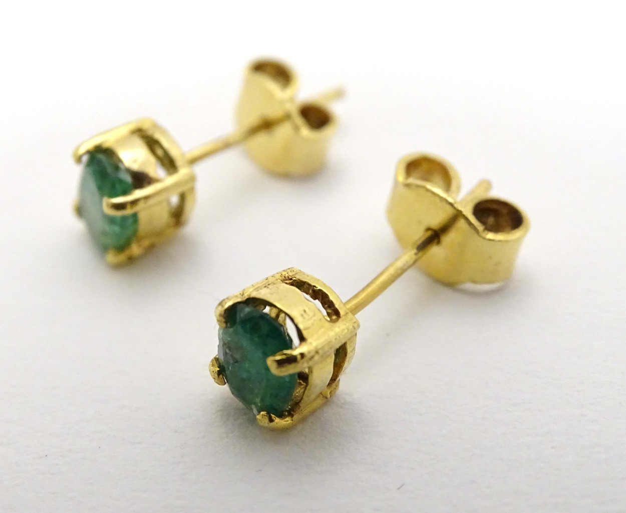 A pair of 9ct gold earrings set with emerald green stones CONDITION: Please Note -