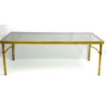Mid Century Modern : a brass and glass topped dining table with triple gathered column legs and