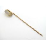 A yellow metal stick pin surmounted by moonstone cabochon 2 1/2" long CONDITION: