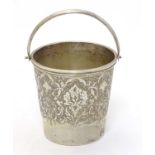 A small white metal bucket with engraved decoration and marked under,