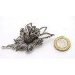 A silver brooch formed as a flower head set with marcasite detail.