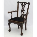 An Irish mid 18thC mahogany butlers chair with carved ears and pierced back splat,
