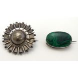 An oval white metal brooch set with malachite cabochon 1" wide,