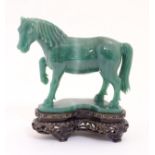 A green banded jade horse on shaped hardwood stand 5 1/2" long x 5 3/4" high CONDITION: