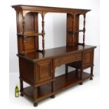 A late 19thC / early 20thC walnut sideboard having a moulded cornice above two sets of shelves