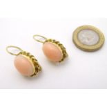 A pair of 18ct gold earrings set with coral cabochon .