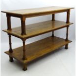 A late 19thC large oak three tier free standing shop fitting with canted supports having carved