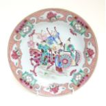 A Chinese Famille Rose enamelled plate depicting a warrior on horseback and other oriental figures,