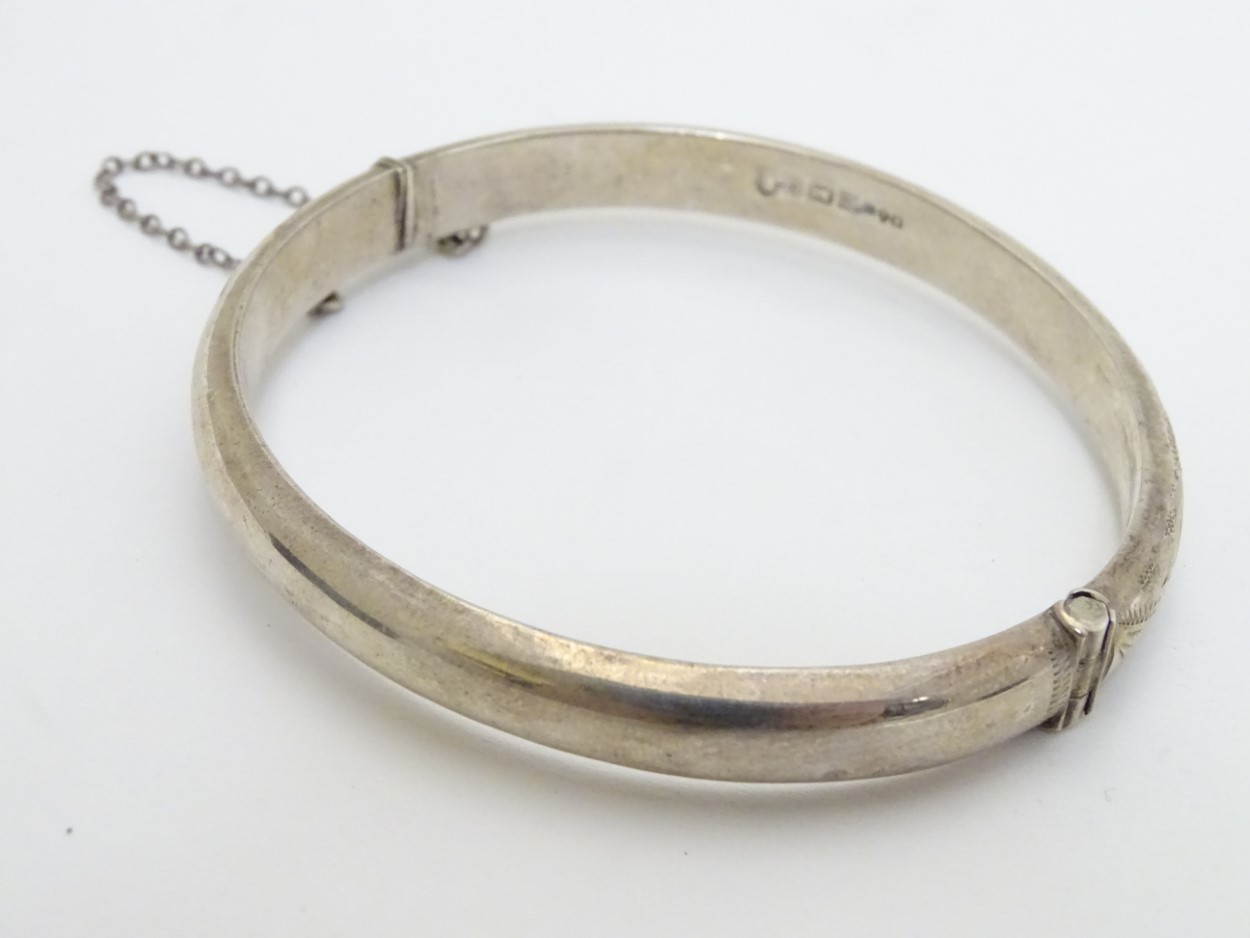 A silver bangle with engraved decoration. Hallmarked Birmingham 1977. Maker R. J. Crafts. - Image 3 of 6