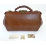 A small pigskin gladstone bag with brass catches and lock,