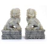 A pair of Chinese grey jadeite like temple dogs on squared socles. (handed).