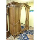 An early 20thC triple armoire with painted floral decoration and applied mouldings,