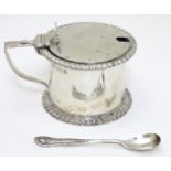 A silver mustard pot with hinged lid and blue glass liner,