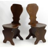 A pair of early / mid 18thC mahogany hall chairs with vase shaped backs and dished seats,