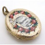 A 9ct gold pendant locket of oval form with enamel decoration.