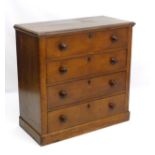 An early Victorian oak chest of drawers comprising four long drawers with turned wooden handles,